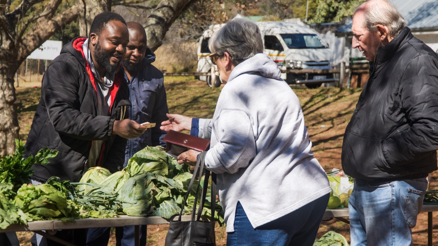 Fresh produce changing hands at a Melville weekend market